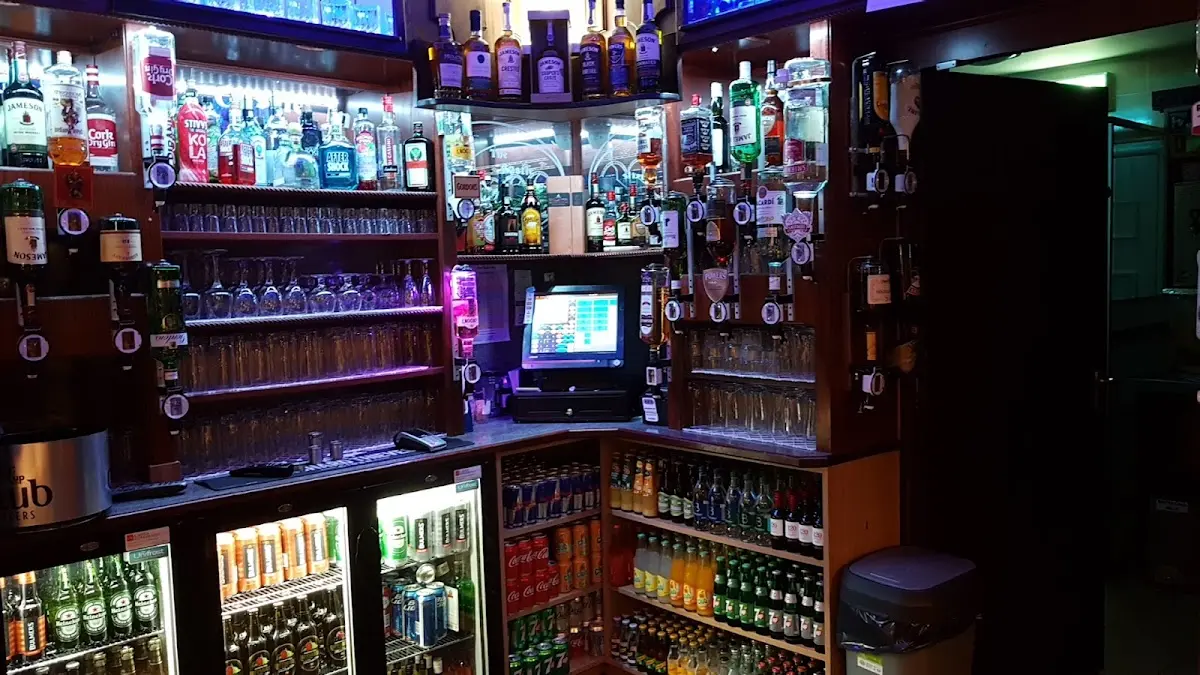 The bar counter at The Castle Inn with spirits, taps, and fridges