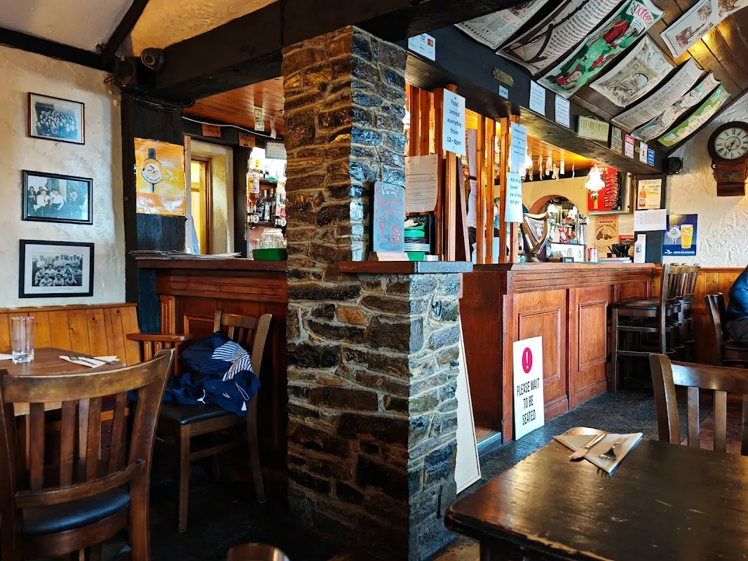 The Castle Inn interior with stone walls, wooden furniture, and framed pictures